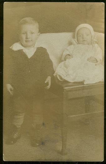 Image for REAL PHOTO POSTCARD OF LITTLE BOY STANDING NEXT TO BABY