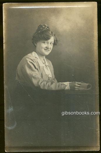 Image for REAL PHOTO POSTCARD OF MADGE SITTING AT A TABLE