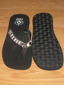of NEW REEF BAMBO FLIP FLOPS. The shoes are black with zebra print ...